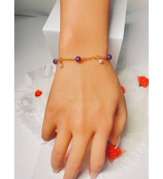 Bracelet doré avec perles violettes et breloque blanches