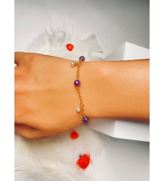 Bracelet doré avec perles violettes et breloque blanches