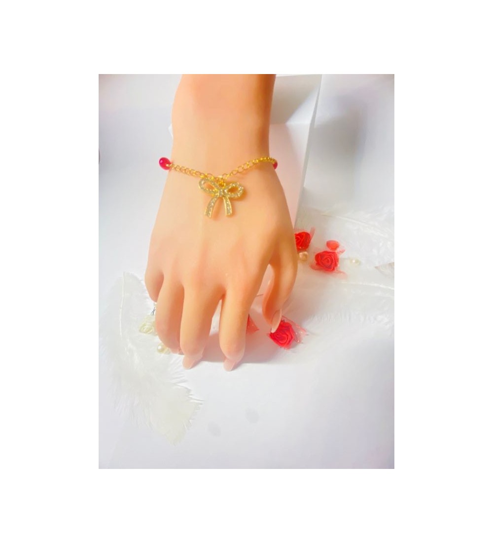 Bracelet doré avec perles rouges et pendentif nœud