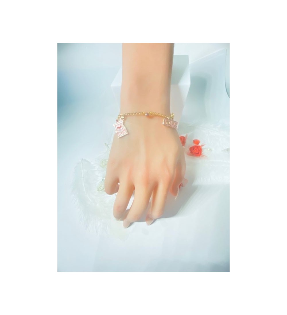 Bracelet doré avec perles bicolores et pendentif rose