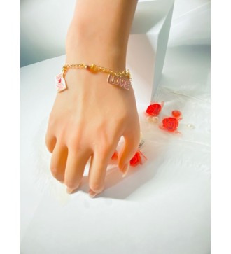 Bracelet doré avec perles bicolores et pendentif rose