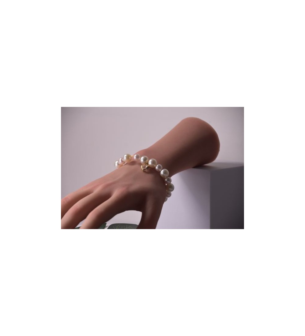 Bracelet en perles blanches avec pendentif coeur doré